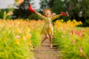 Little-girl-red-rubber-boots-straw-hat-watering-red-watering-flowers-garden (1)